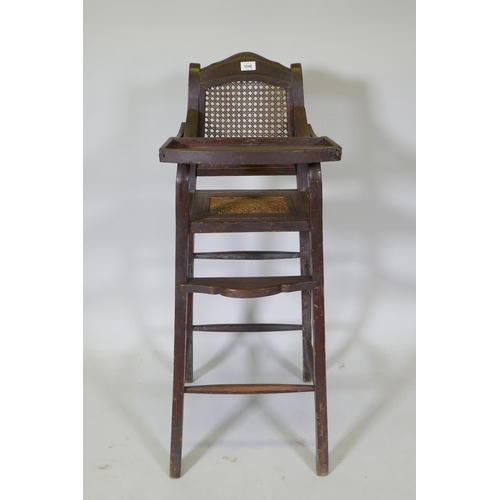 1046 - An oriental hardwood child's highchair with can back and seat, 103cm high