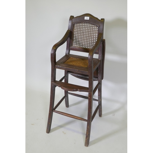 1046 - An oriental hardwood child's highchair with can back and seat, 103cm high