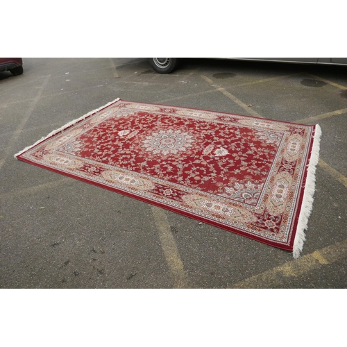 1048 - A fine woven full pile rich red ground Qom carpet, with floral medallion design and floral borders, ... 