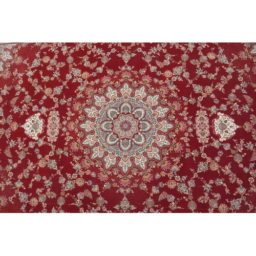 1048 - A fine woven full pile rich red ground Qom carpet, with floral medallion design and floral borders, ... 