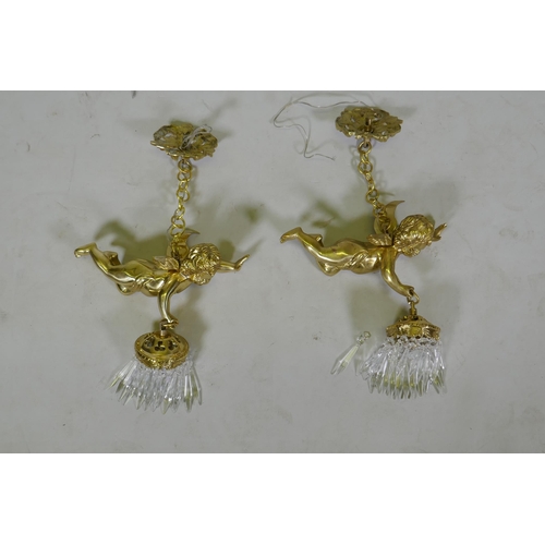 1052 - A pair of French style gilt metal pendant lights in the form of winged putti, with glass lustres, 60... 