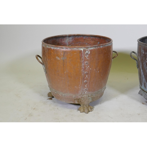 1069 - A near pair of copper planters/jardinieres of rivetted construction, raised on paw feet, and another... 