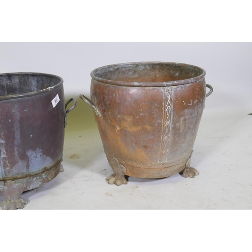 1069 - A near pair of copper planters/jardinieres of rivetted construction, raised on paw feet, and another... 