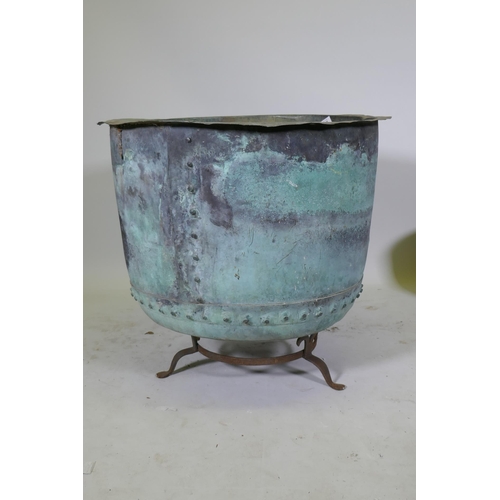 1070 - A large antique rivetted copper planter, raised on an iron stand, 73cm diameter, 55cm high