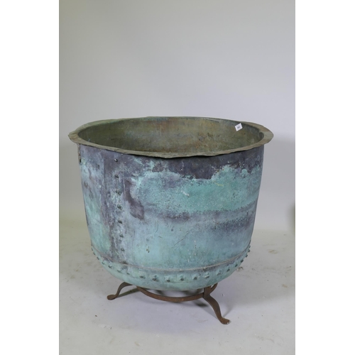 1070 - A large antique rivetted copper planter, raised on an iron stand, 73cm diameter, 55cm high