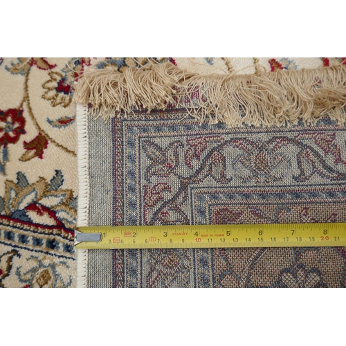 1072 - An ivory ground full pile Kashmir carpet with allover floral design and gold borders, 200 x 300cm