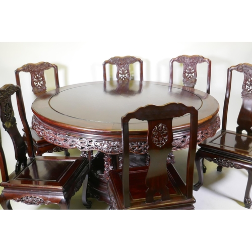 1079 - A Chinese rosewood dining table, with carved and pierced frieze, raised on a carved base decorated w... 