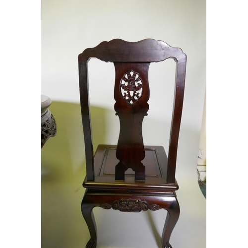 1079 - A Chinese rosewood dining table, with carved and pierced frieze, raised on a carved base decorated w... 