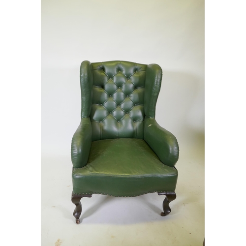 1084 - An early C20th button back leather wing armchair, raised on cabriole supports