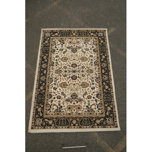 1086 - A Belgian cream ground rug with Oriental allover floral design and black borders, 150 x 212cm