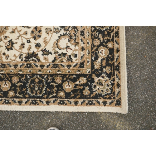 1086 - A Belgian cream ground rug with Oriental allover floral design and black borders, 150 x 212cm