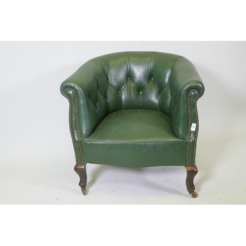 1087 - An early C20th button back leather tub chair with brass stud detail, raised on shaped supports