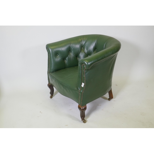 1087 - An early C20th button back leather tub chair with brass stud detail, raised on shaped supports