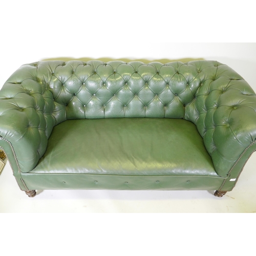 1089 - A Victorian button back leather Chesterfield settee, raised on turned supports, 165cm wide