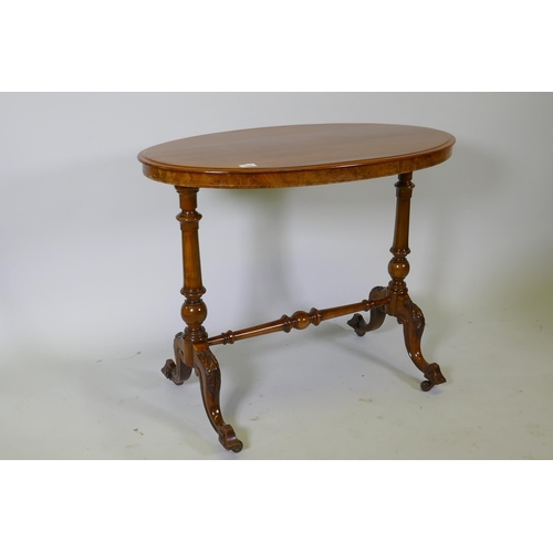 1094 - A Victorian walnut stretcher table, oval top raised on turned end columns with carved cabriole suppo... 