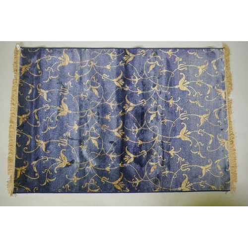 1099 - A blue ground Kashmir rug with gold scrolling floral design, 170 x 100cm