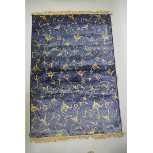 1099 - A blue ground Kashmir rug with gold scrolling floral design, 170 x 100cm