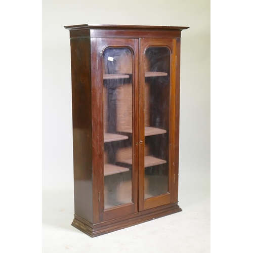 1117 - A Victorian mahogany bookcase with two arched glazed doors, raised on a shaped plinth, 86 x 30 x 138... 