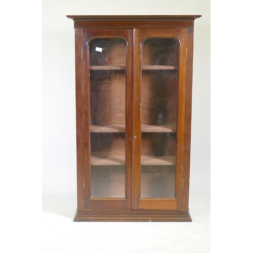 1117 - A Victorian mahogany bookcase with two arched glazed doors, raised on a shaped plinth, 86 x 30 x 138... 