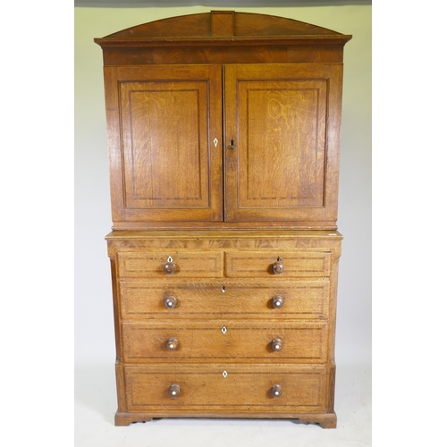 1121 - An early C19th oak linen press/housekeeper's cupboard, the upper section with two doors, fitted with... 