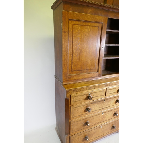 1121 - An early C19th oak linen press/housekeeper's cupboard, the upper section with two doors, fitted with... 