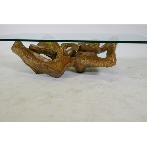 1122 - A contemporary coffee table with glass top and reconstituted stone base, 80 x 130cm