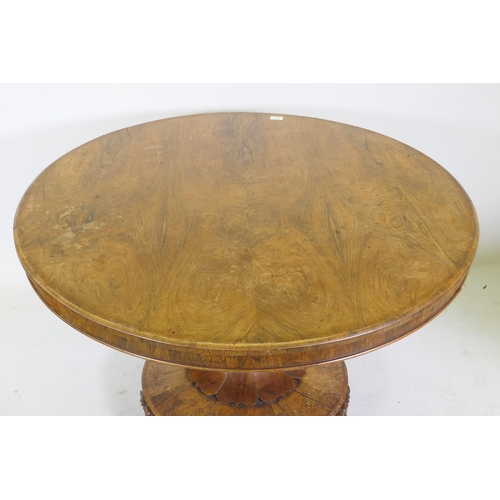 1134 - A C19th rosewood tilt top breakfast table, raised on a shaped column with carved detail and platform... 