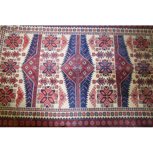 1158 - A Caucasian Kazak wool carpet with geometric designs on a red field, 200 x 300cm