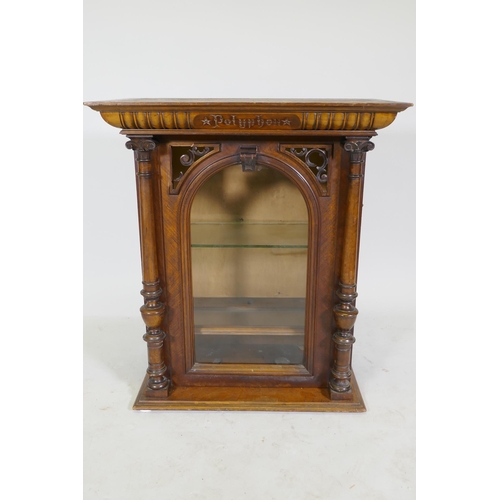 1175 - A walnut polyphon case, with pierced spandrels and arched glazed door with apple columns, 62 x 36 x ... 