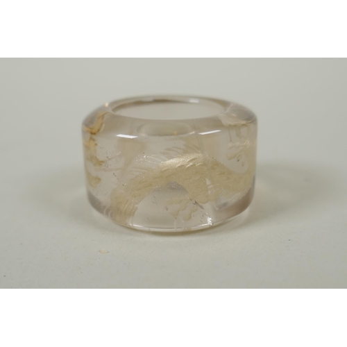 118 - A Chinese crystal archers thumb ring, with engraved dragon decoration, and a nephrite jade thumb rin... 