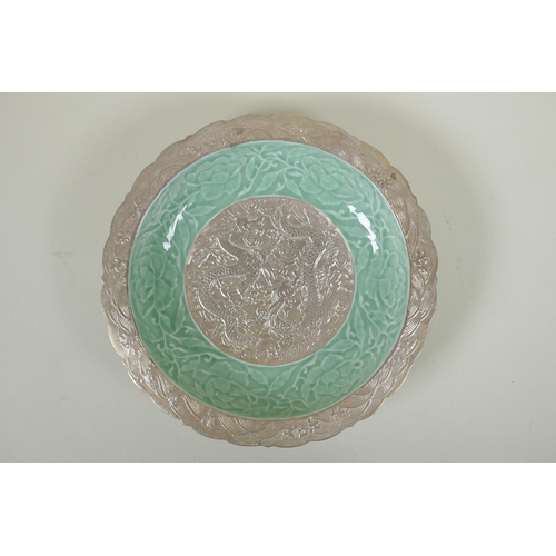 123 - A Chinese celadon and silver glazed porcelain dish with raised dragon and lotus flower decoration, Q... 