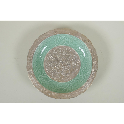 123 - A Chinese celadon and silver glazed porcelain dish with raised dragon and lotus flower decoration, Q... 