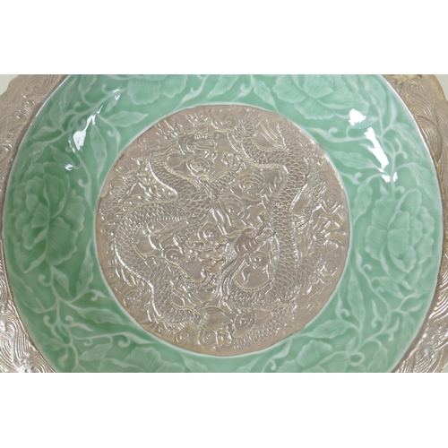 123 - A Chinese celadon and silver glazed porcelain dish with raised dragon and lotus flower decoration, Q... 