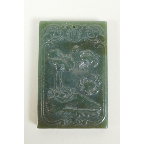 130 - A Chinese spinach jade pendant with carved decoration of crabs and lotus flowers, 4 x 6cm