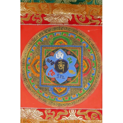 138 - A Tibetan hand painted Mandala, in an embroidered silk mount, 53 x 67cm