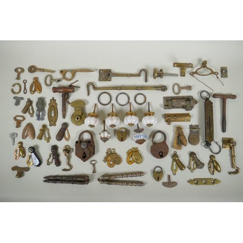 141 - A collection of antique bronze and brass door furniture, porcelain drawer handles, locks and keys