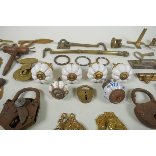 141 - A collection of antique bronze and brass door furniture, porcelain drawer handles, locks and keys