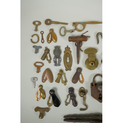 141 - A collection of antique bronze and brass door furniture, porcelain drawer handles, locks and keys