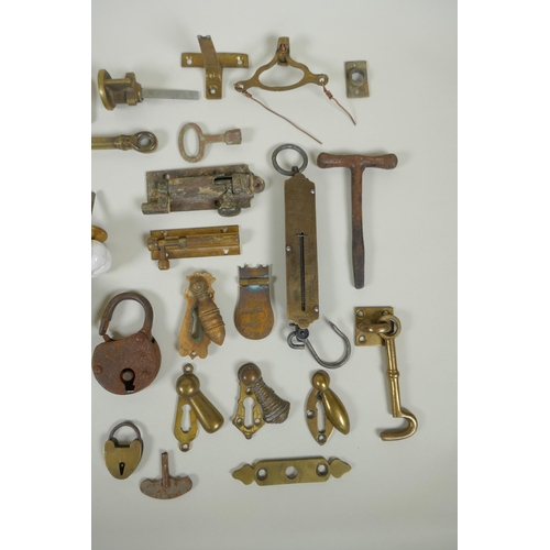 141 - A collection of antique bronze and brass door furniture, porcelain drawer handles, locks and keys