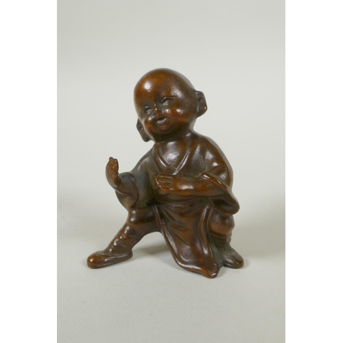 142 - An Oriental bronze figure of a child practising martial arts, 9cm high