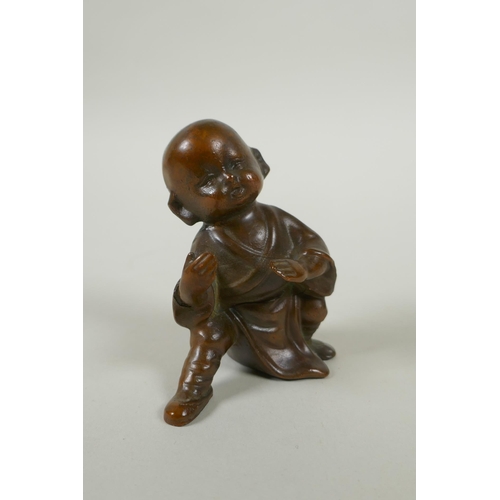 142 - An Oriental bronze figure of a child practising martial arts, 9cm high