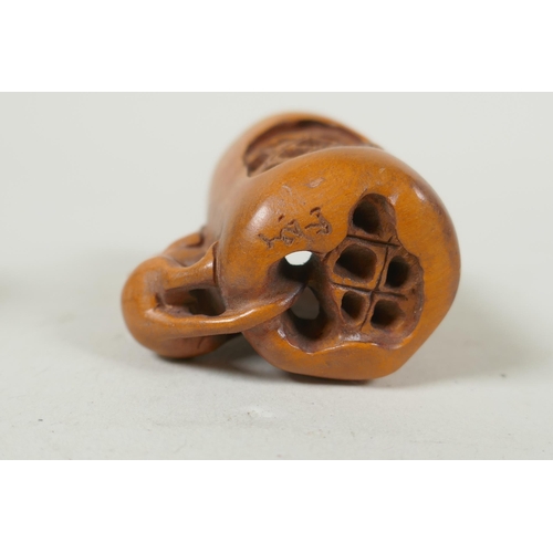 143 - A Japanese carved boxwood rat netsuke, together with two carved tagua nut netsuke in the form of a m... 