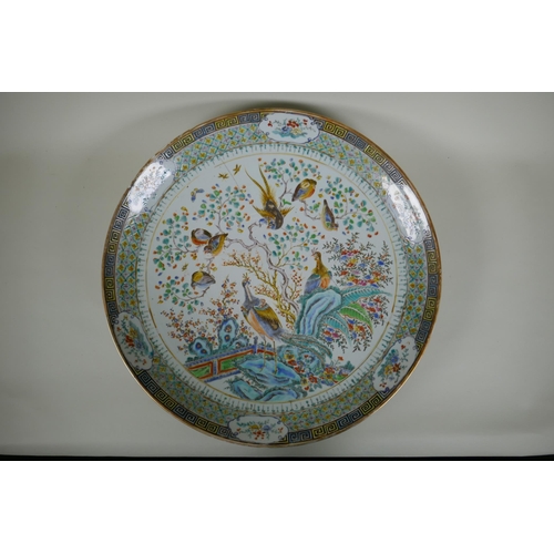 15 - An C18th/C19th Chinese famille verte porcelain charger decorated with peacocks and asiatic birds per... 