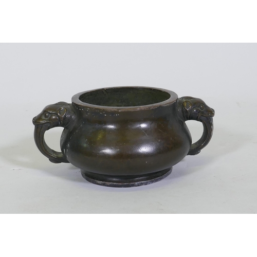 162 - A Chinese bronze censer with dragon mask handles, seal mark to base, 19cm diameter