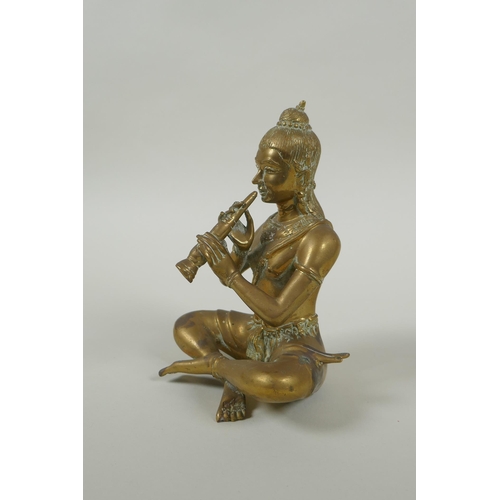 171 - A Cambodian bronze figure of a seated musician playing a flute, 15cm high