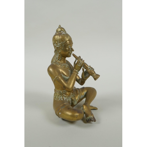 171 - A Cambodian bronze figure of a seated musician playing a flute, 15cm high