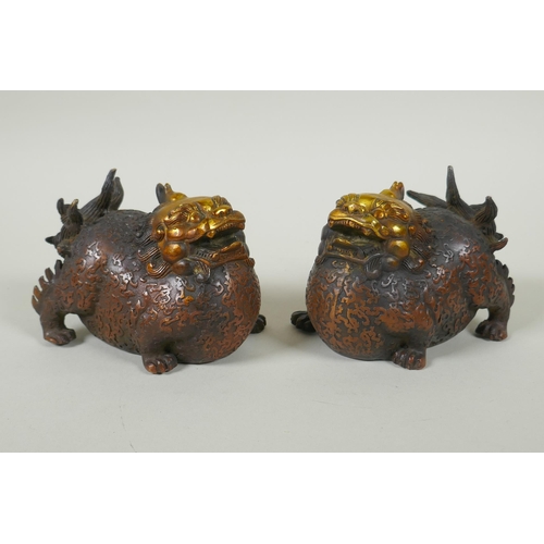 173 - A pair of Chinese filled bronze kylin with gilt heads, 11cm long