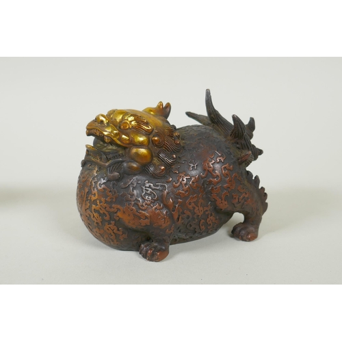 173 - A pair of Chinese filled bronze kylin with gilt heads, 11cm long