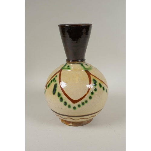 179 - An antique Islamic earthenware vase with cream glazed body and treacle glazed neck, 25cm high