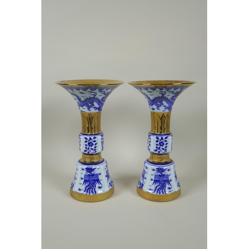 188 - A pair of Chinese blue and white gu shaped vases with banded gilt highlights, and decorated with pho... 